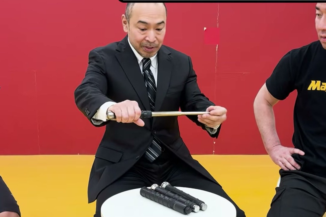 三段式の特殊警棒を振り出して伸ばすところ