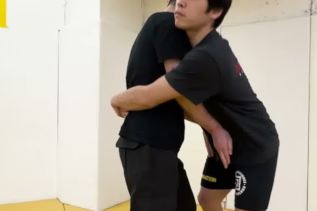 正面から抱きつかれた密着状態の対処例を実演するところ